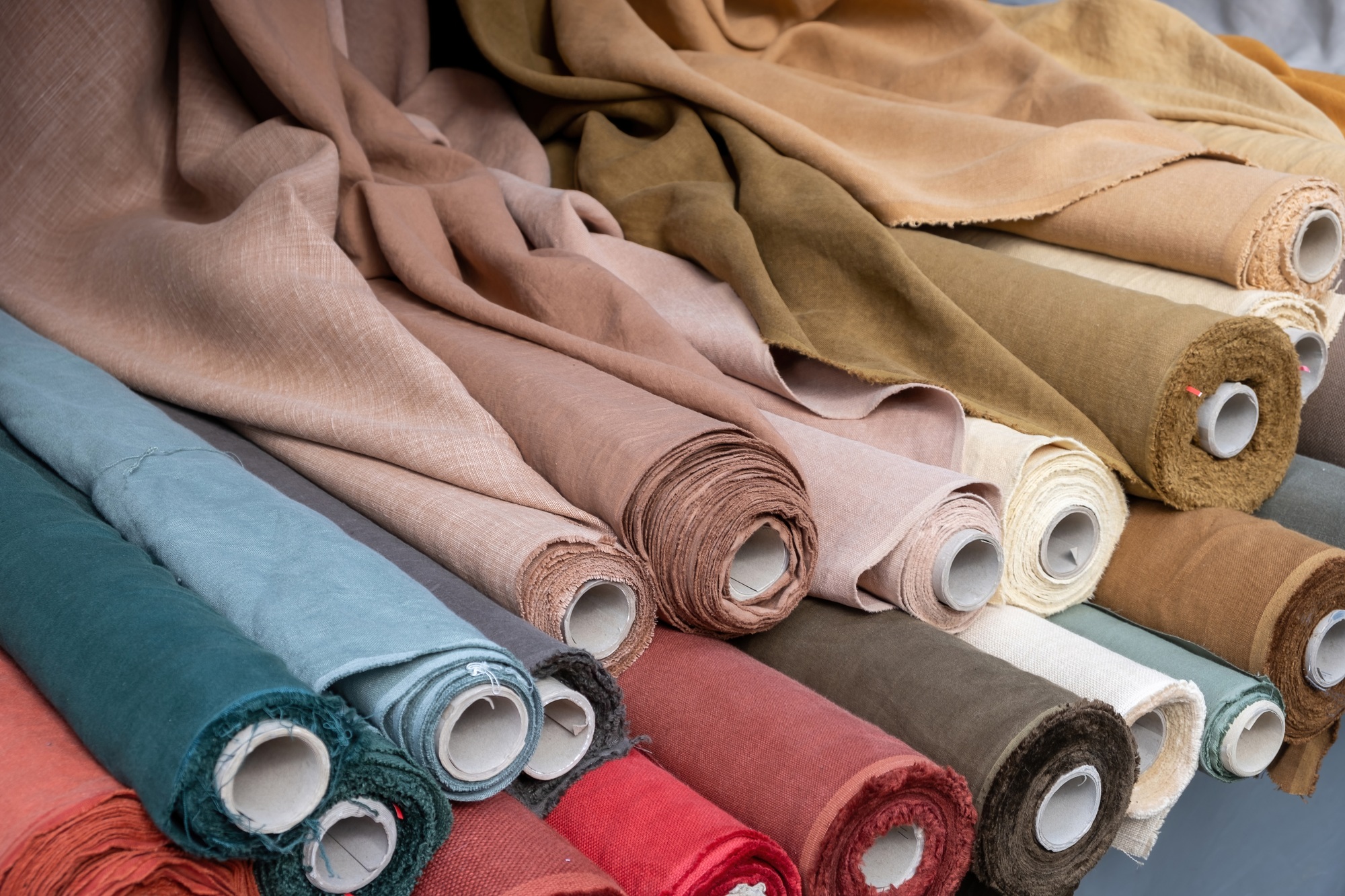 Fabric roll background. Vintage colorful material reels, retail market stall, close up view