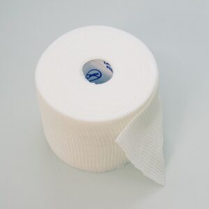 Top view of a sterile gauze bandage roll isolated on a gray background on the left side